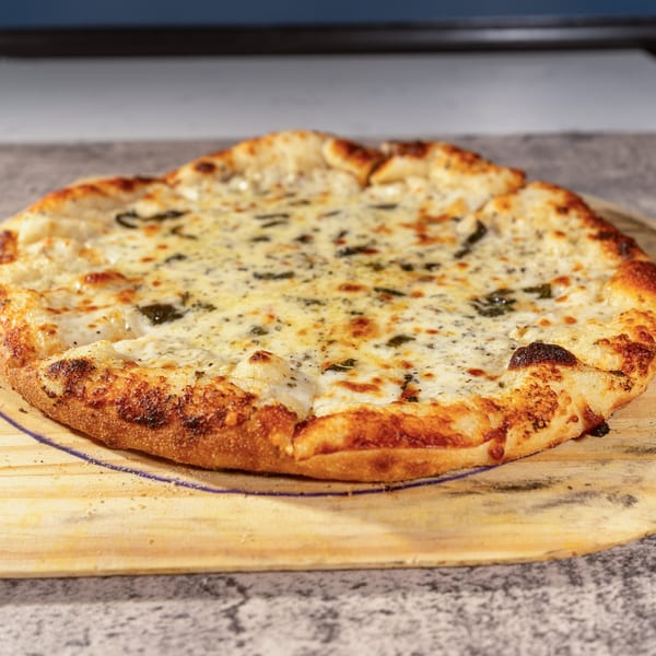 A freshly baked white pizza with melted cheese and herbs on a wooden pizza peel.